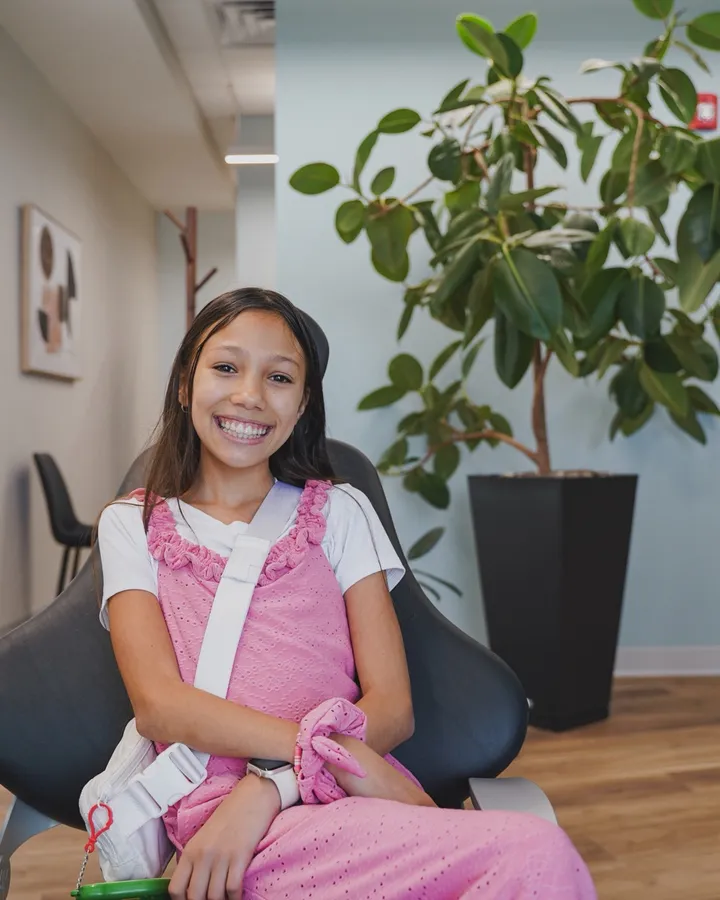 A young patient smiling in the exam chair at Wiktorski Orthodontics