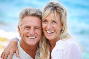 Older couple smiling in outdoor setting | Orthodontics for Adults in Rochester, NY
